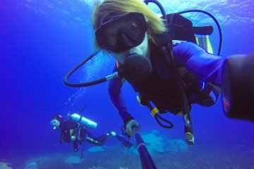 Underwater scuba diving selfie shot with selfie stick. Deep blue sea. Wide angle shot.